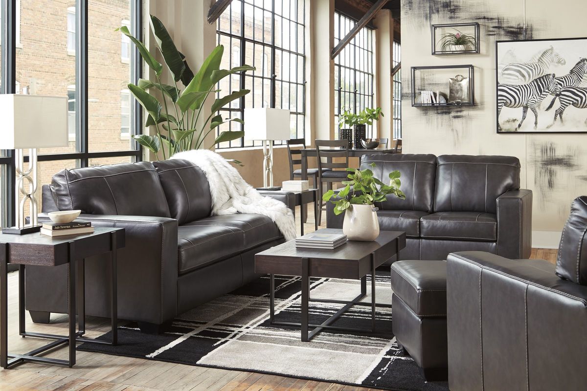 A living room set of leather furniture in dark brown from Ashley Furniture.